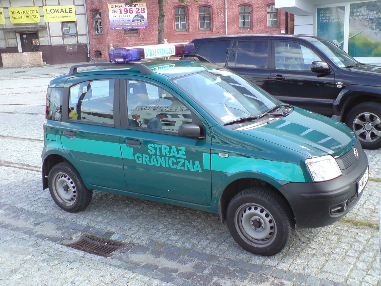A green Fiat Panda II patrol car of the Polish Border Guard is parked on a paved street.