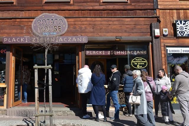 People stand outside a Polish restaurant called Potato House on Krupówki street.