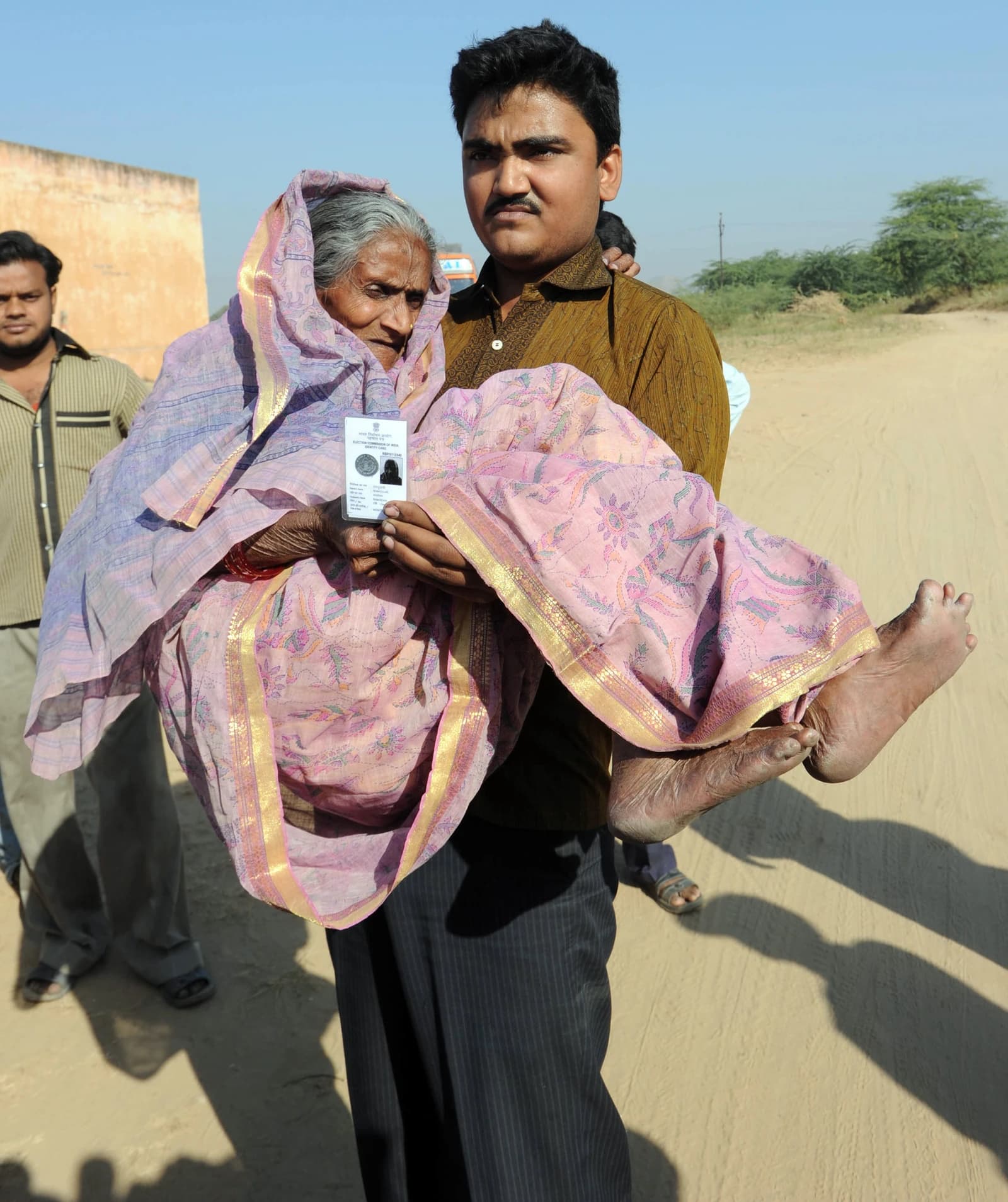 An elderly woman carried by a man to a polling booth in Jaipur, Rajasthan.