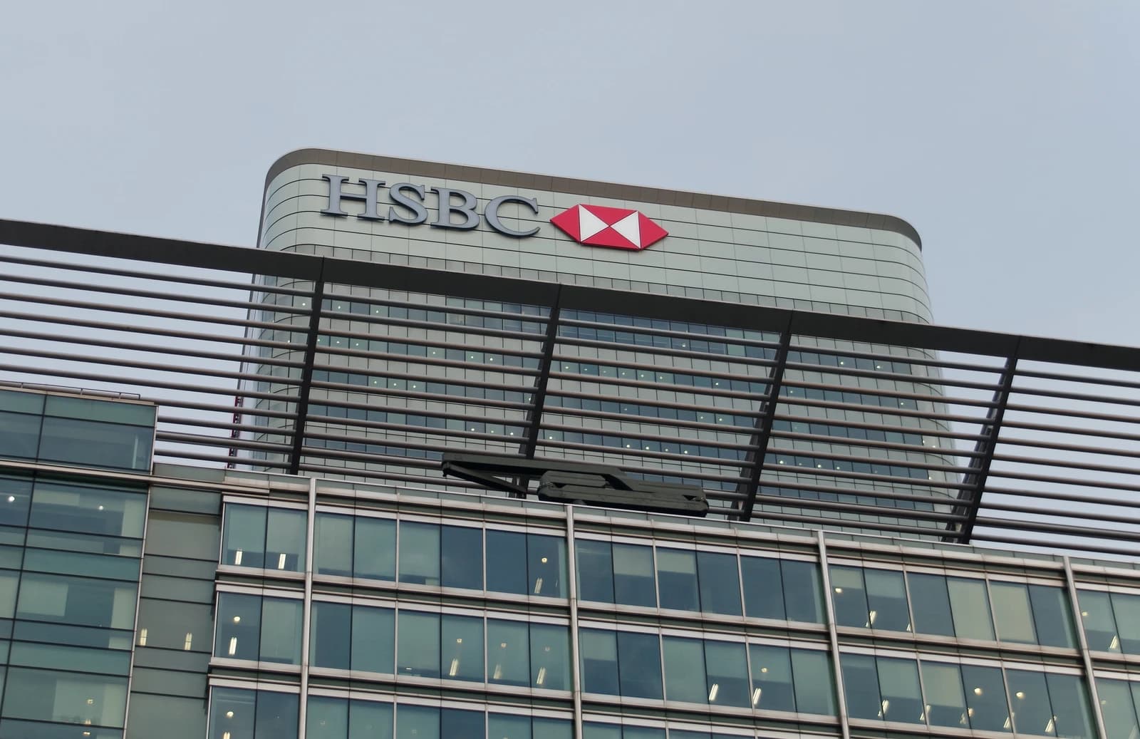 HSBC logo and signage on a tall building in London's Canary Wharf financial district.