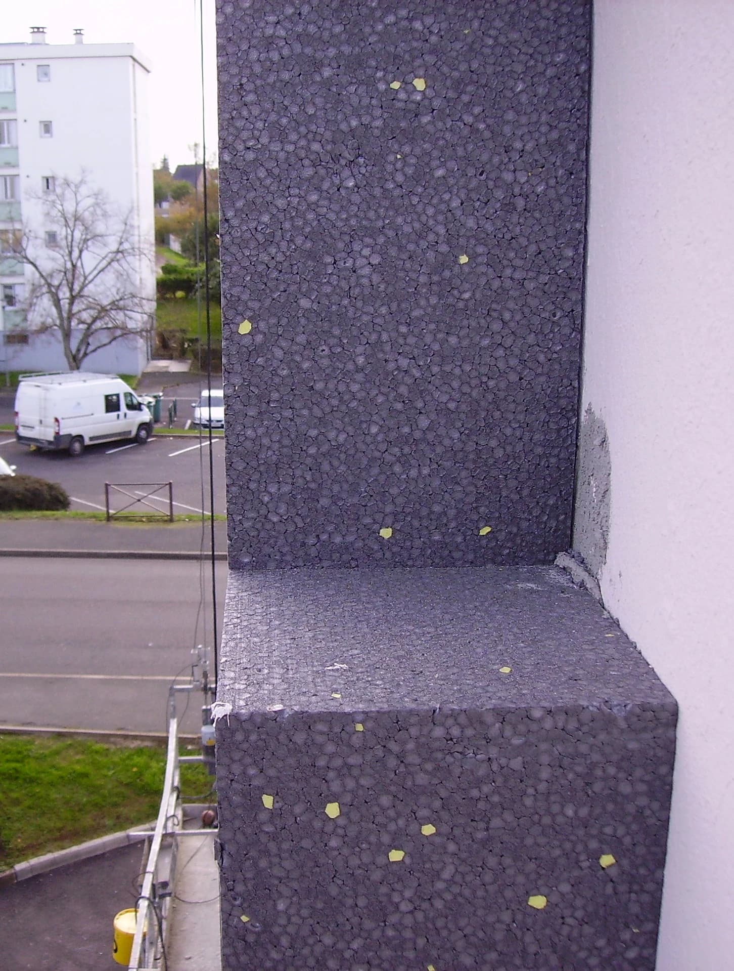 EPS insulation boards are being applied to the exterior of a building facade.