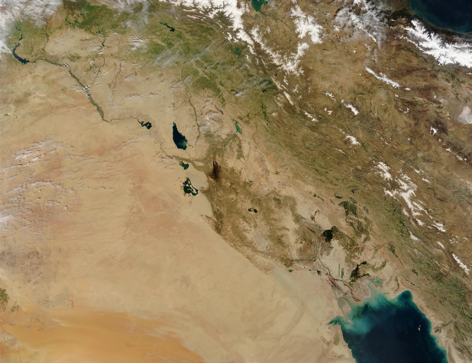 Satellite view of Iraq with smoke plumes from oil fires visible.