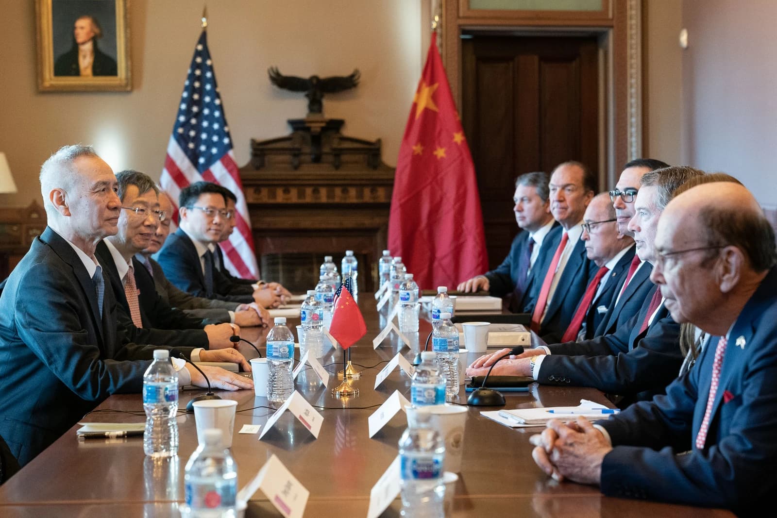 US and Chinese officials sitting across from each other at a long conference table.