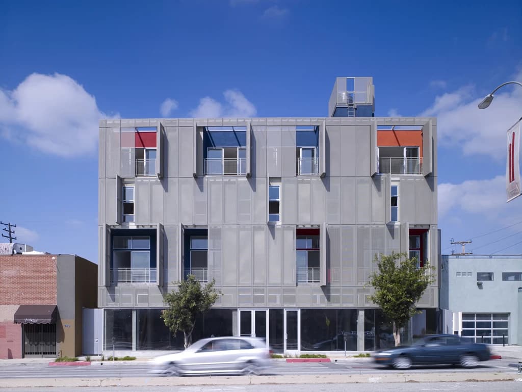 The Cherokee Lofts building in Los Angeles with cars driving on the street.