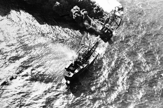 Aerial view of the tanker R. P. Resor burning and emitting smoke at sea.