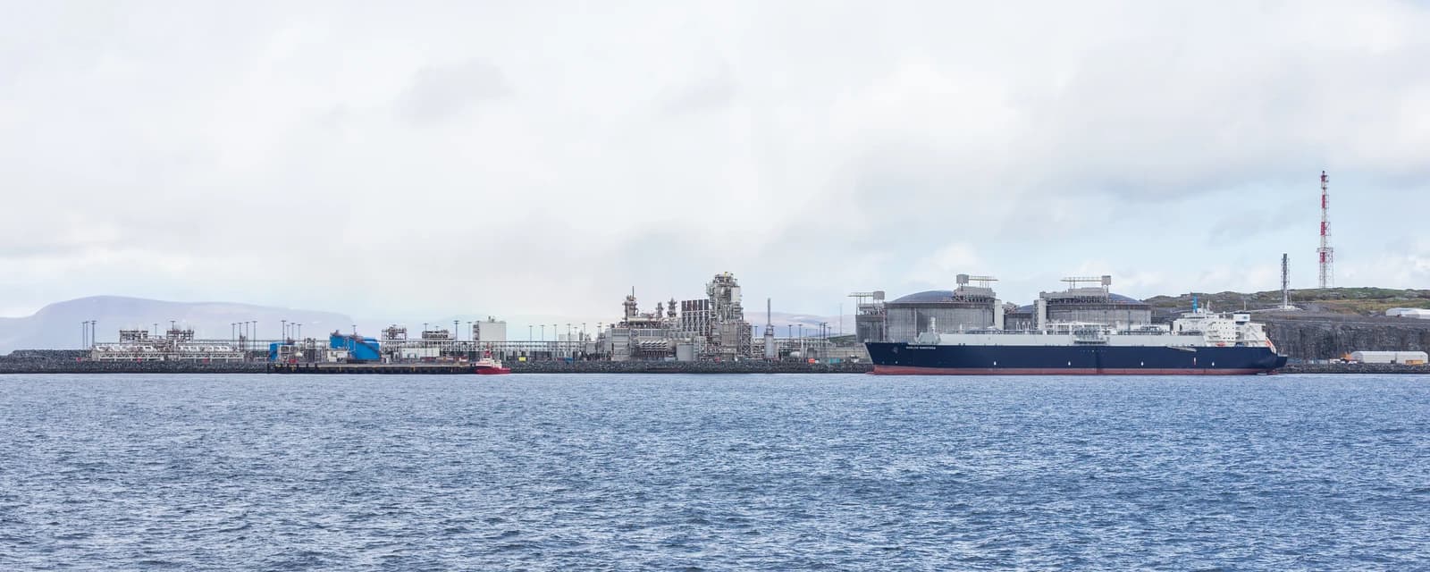 An LNG tanker, the Gaslog Saratoga, docked at a large gas terminal facility.