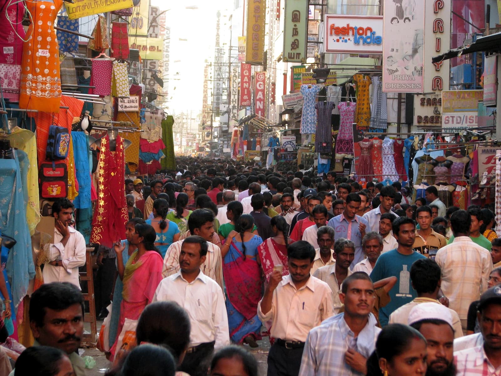 A bustling street in Chennai, India, filled with numerous pedestrians and storefronts.