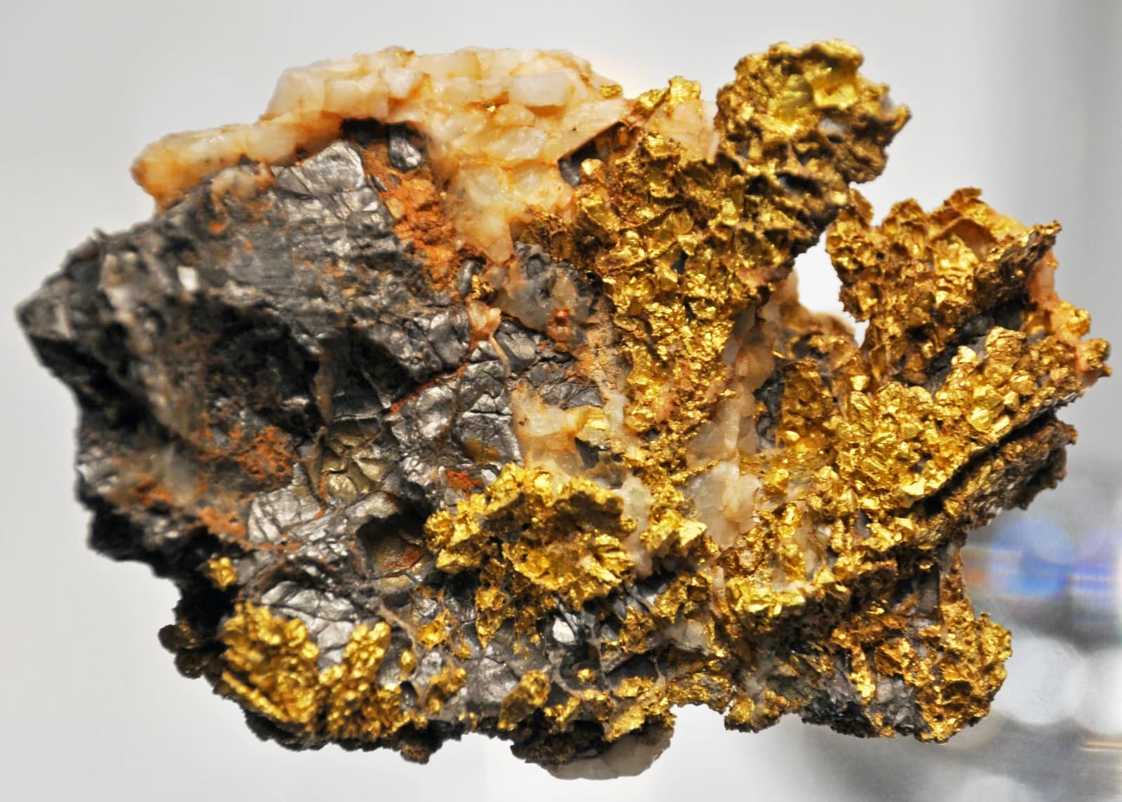 Natural gold and silver embedded within a quartz mineral mass specimen.