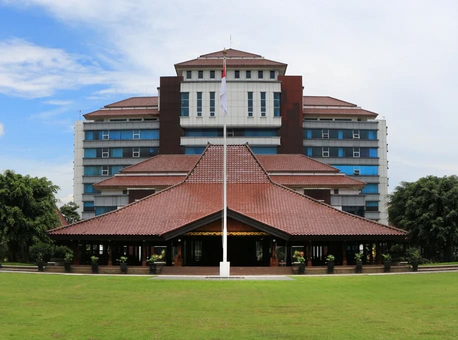 Exterior view of a large building with a traditional roof and a flagpole.