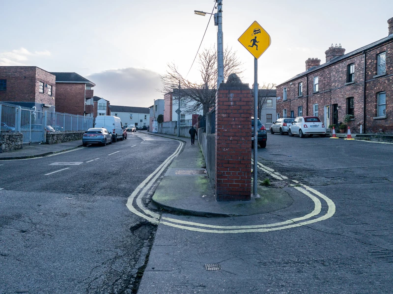 A street in The Liberties area of Dublin with brick buildings and parked cars.