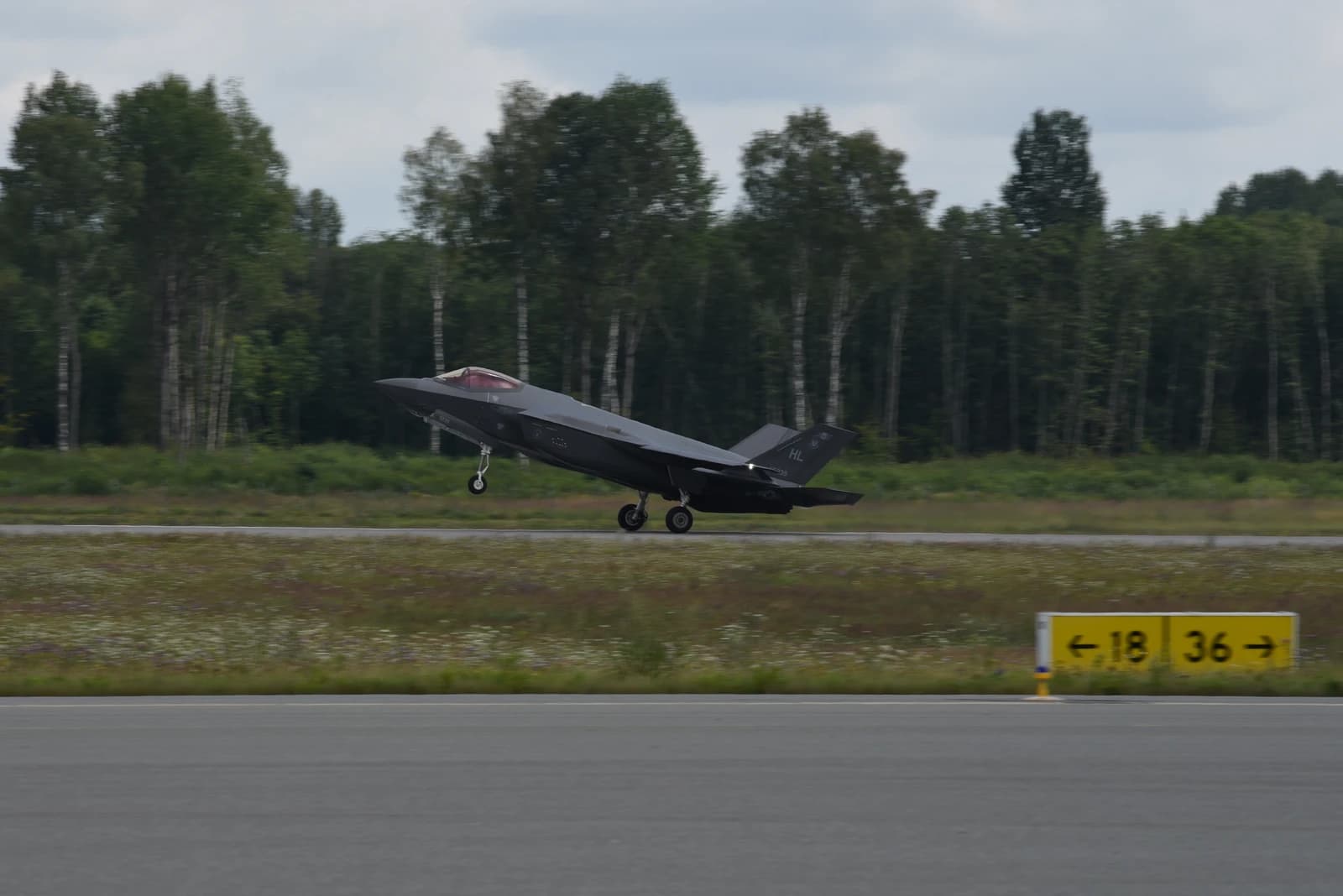 An F-35A Lighting II stealth fighter jet taking off from an airfield.