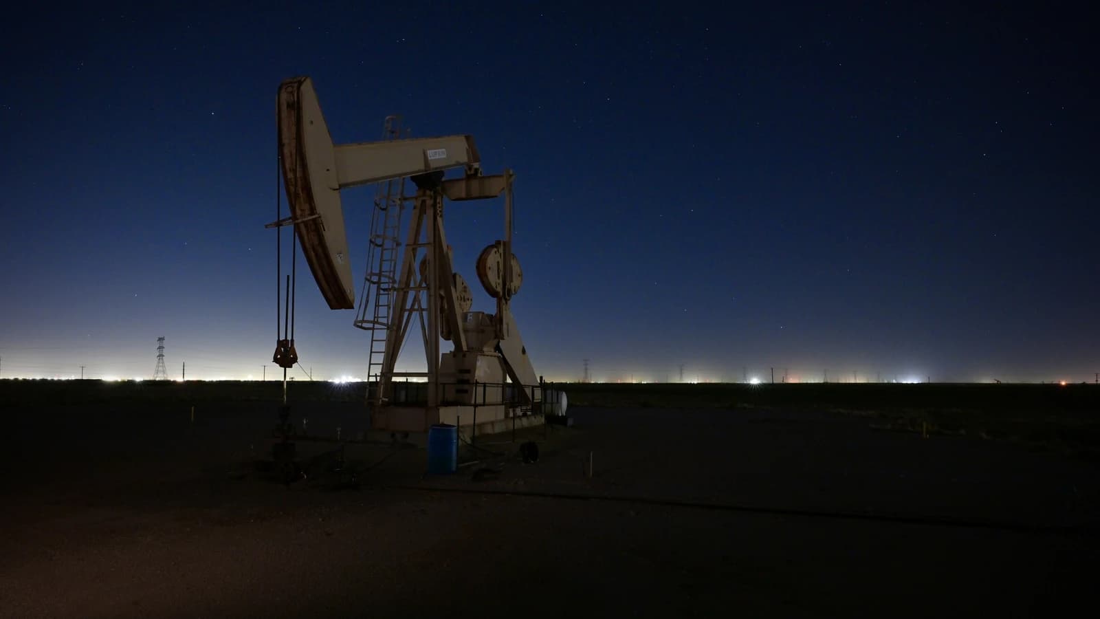 An oil pumpjack extracts crude oil from the ground at night.