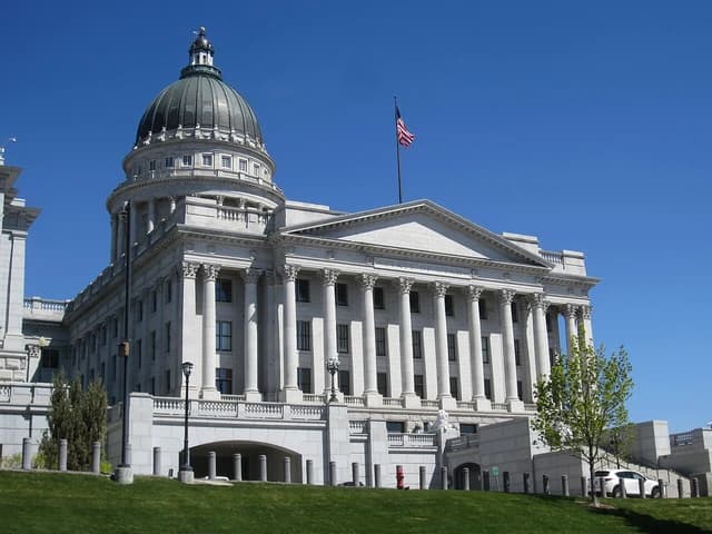 Utah State Capitol building with green grass and clear blue sky.