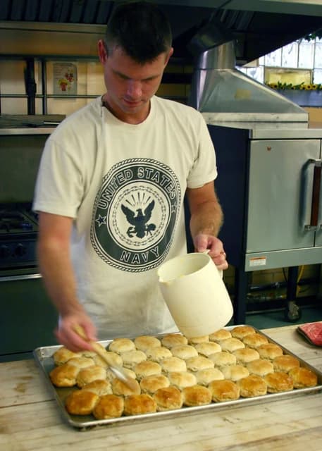 Storekeeper 1st Class Daniel Scott preparing biscuits at the Walnut Hills soup kitchen.