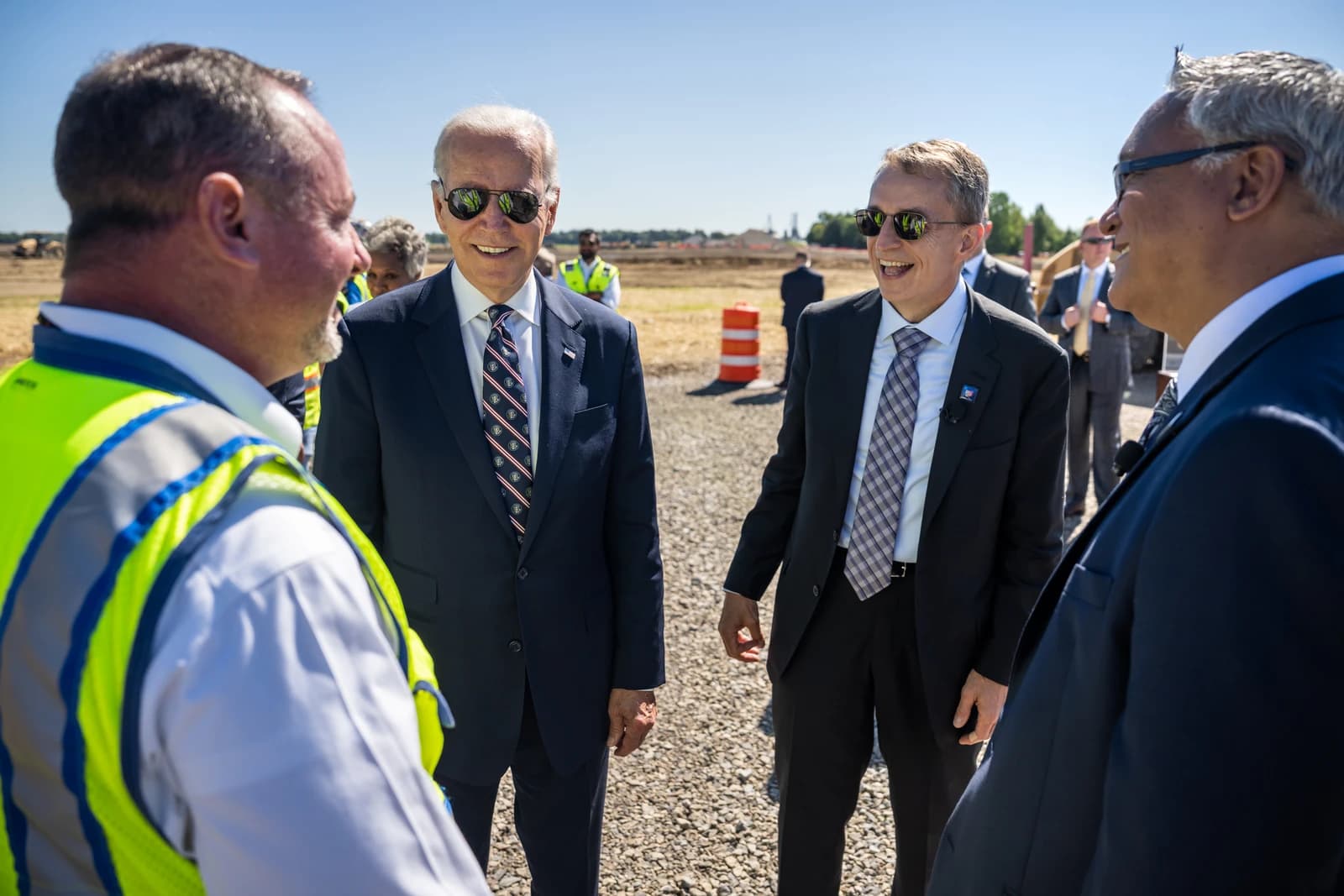 President Joe Biden and Intel CEO Pat Gelsinger interacting outdoors at a construction site.
