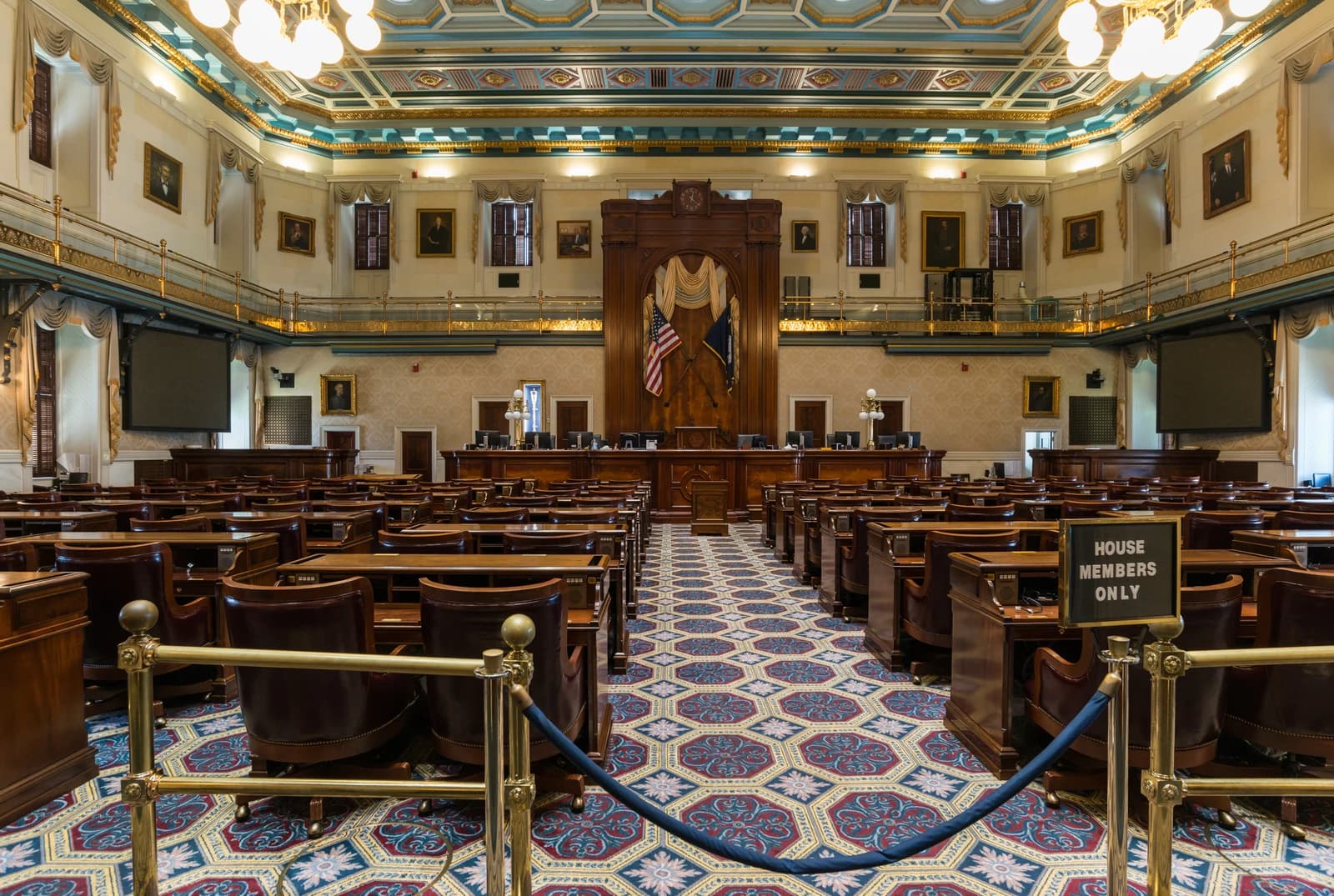 Empty South Carolina State House House Chamber with rows of desks and ornate decor.