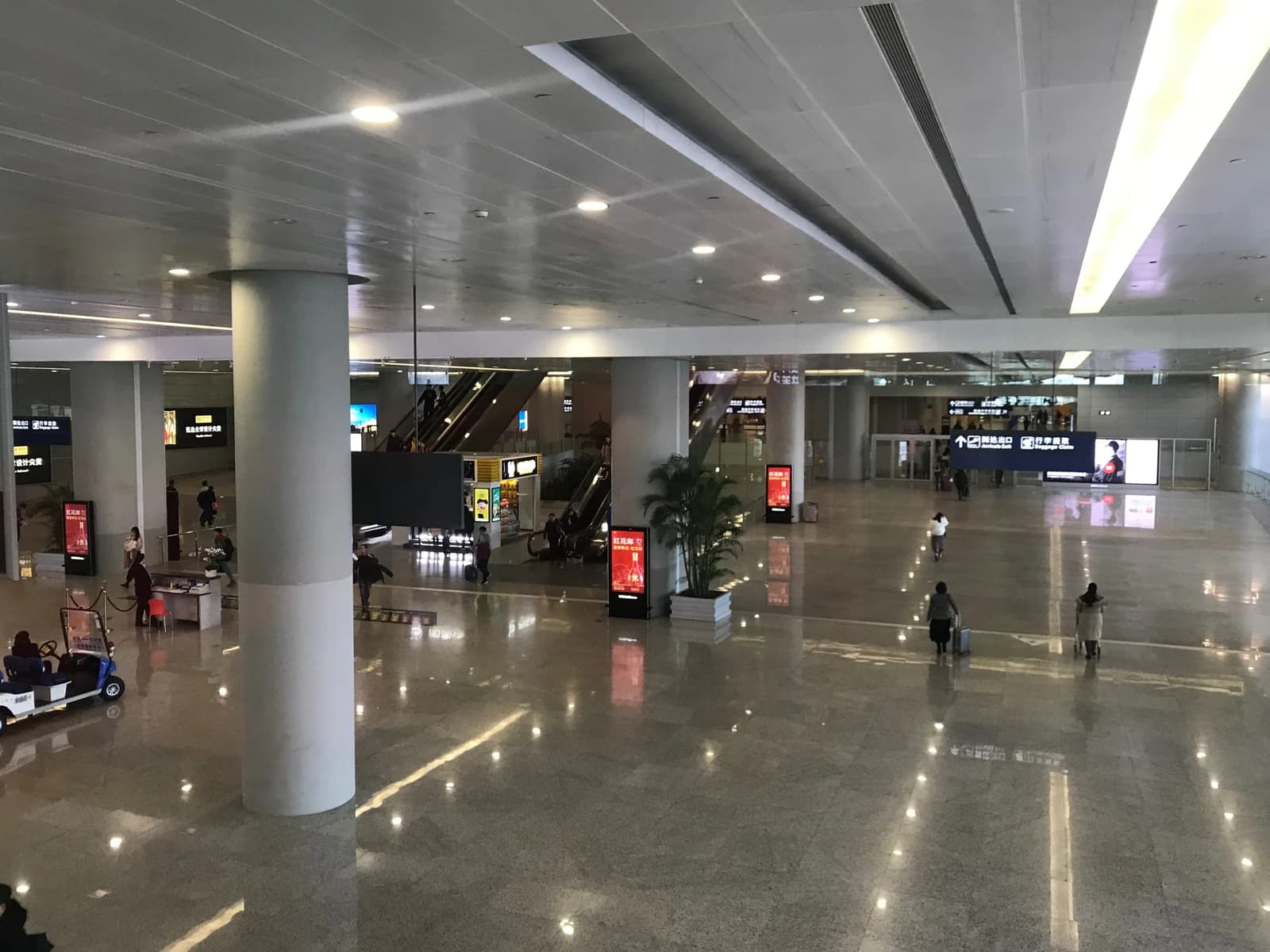 Travelers walk through the domestic lobby of an airport terminal.