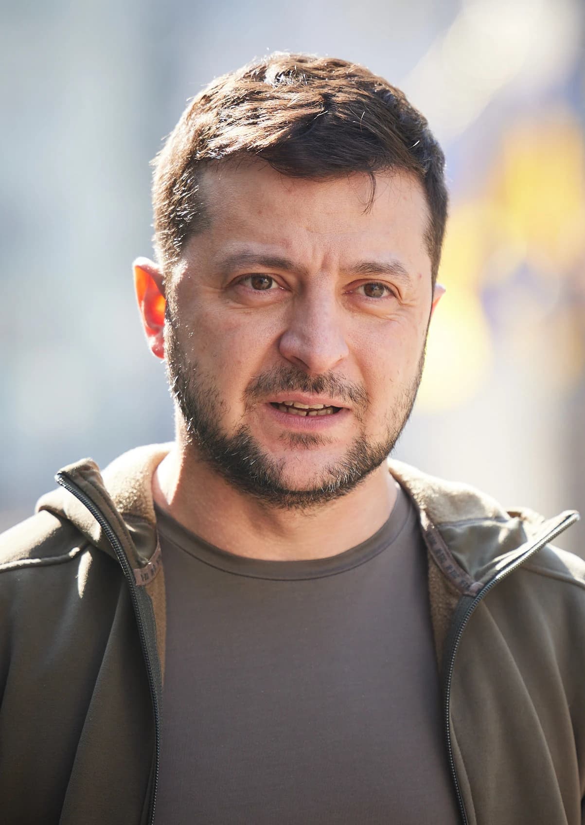Volodymyr Zelenskyy, President of Ukraine, looking at the viewer outdoors.