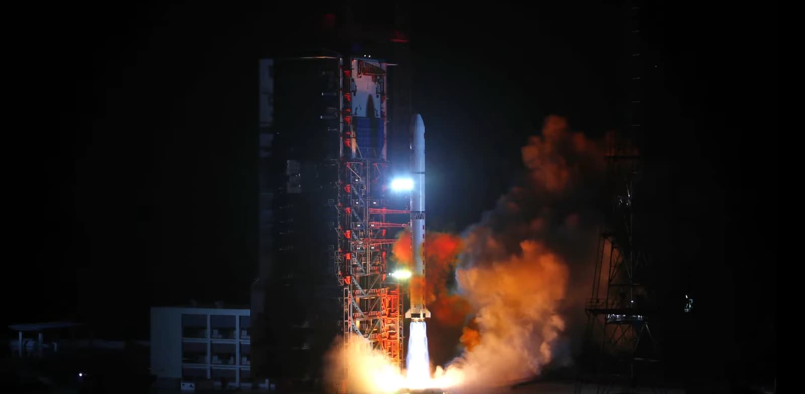 Chinese Yaogan-36 satellite launching into space from a launchpad at night.