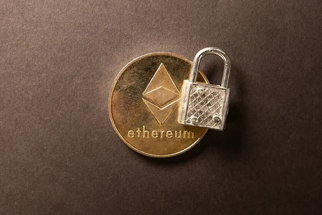 Golden Ethereum cryptocurrency coin with a silver padlock resting on its surface.