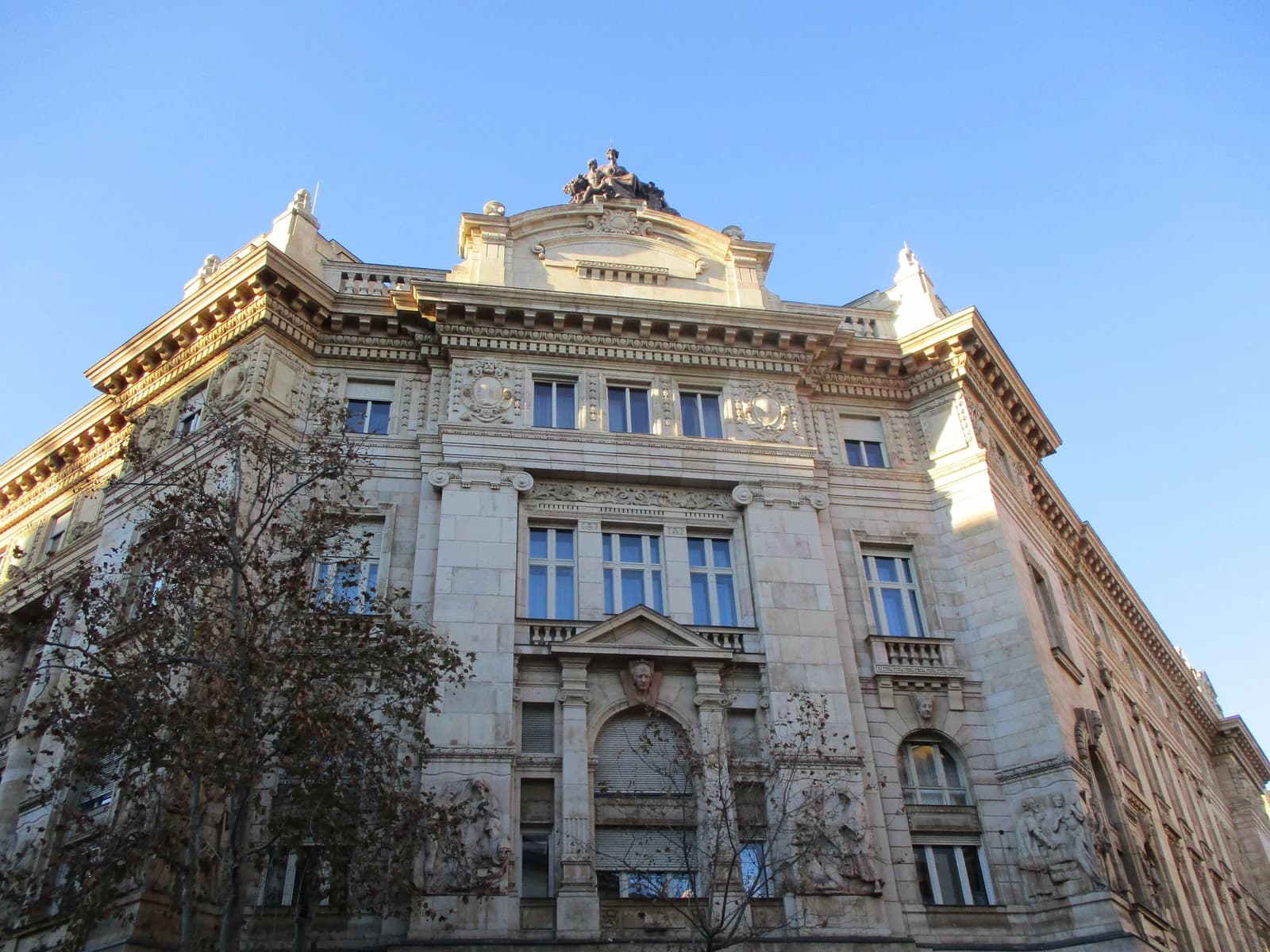 Building of the Hungarian National Bank with ornate facade and statues on the roof.