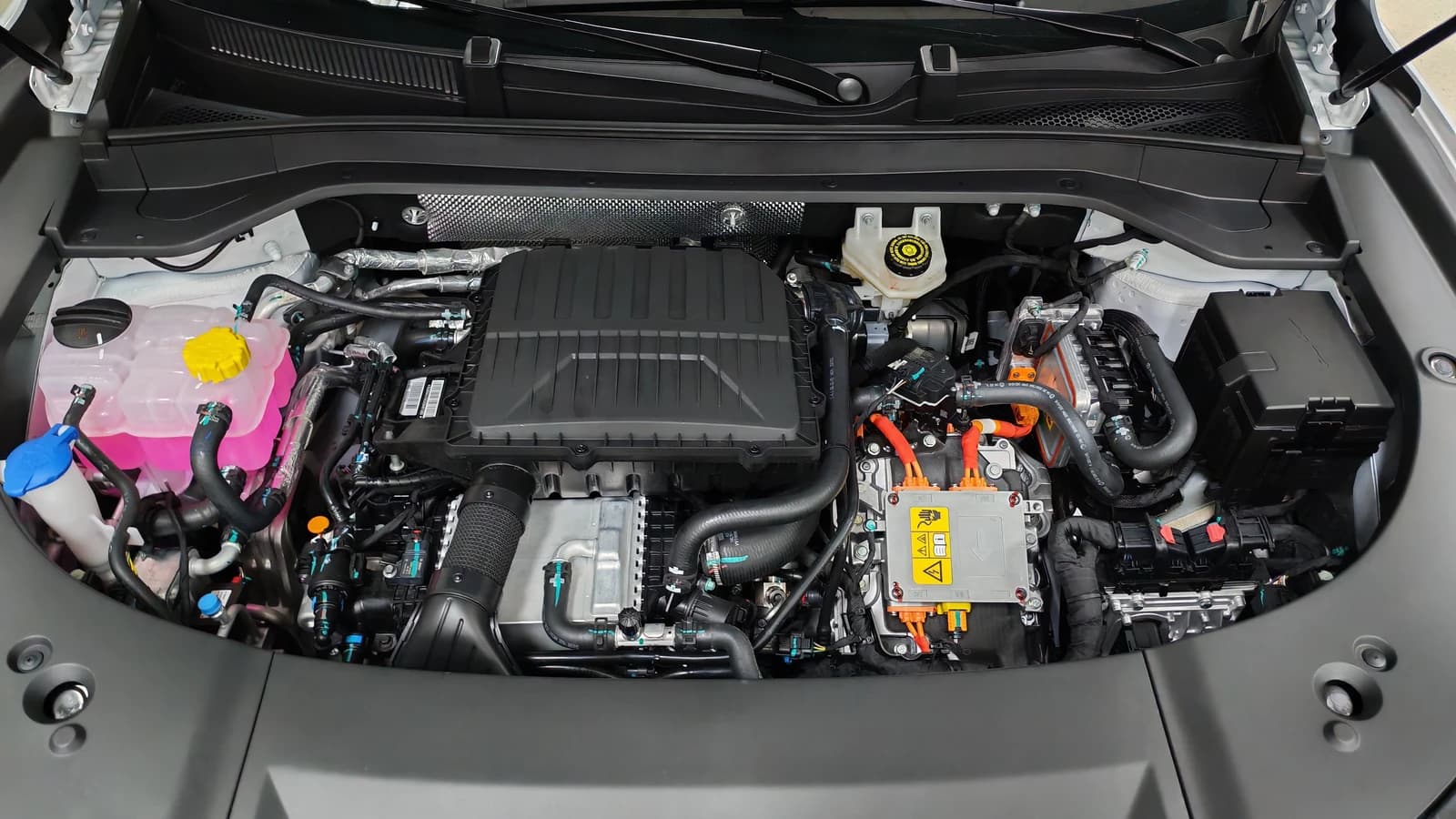 Engine bay of a Jaecoo J8 SHS, revealing hybrid powertrain components and fluids.