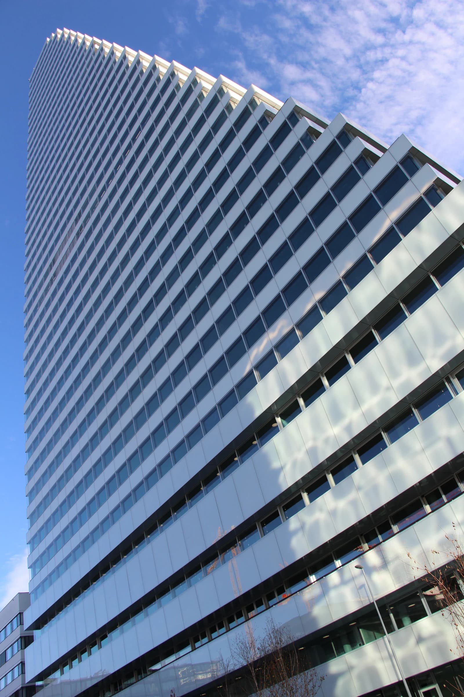 Modern glass and steel building, Roche Building 1, in Basel under a blue sky.