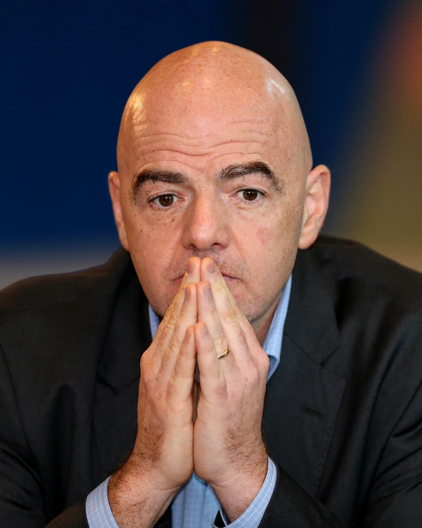 Gianni Infantino, President of FIFA, looking forward with his hands clasped.