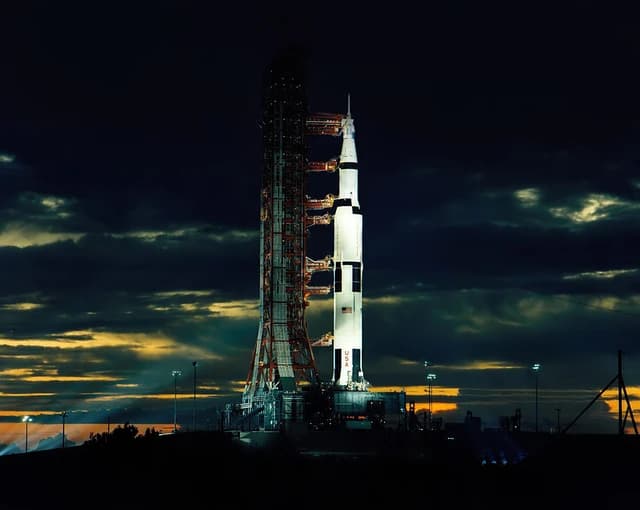 Apollo 17 Saturn V rocket on the launch pad with its launch tower at night.