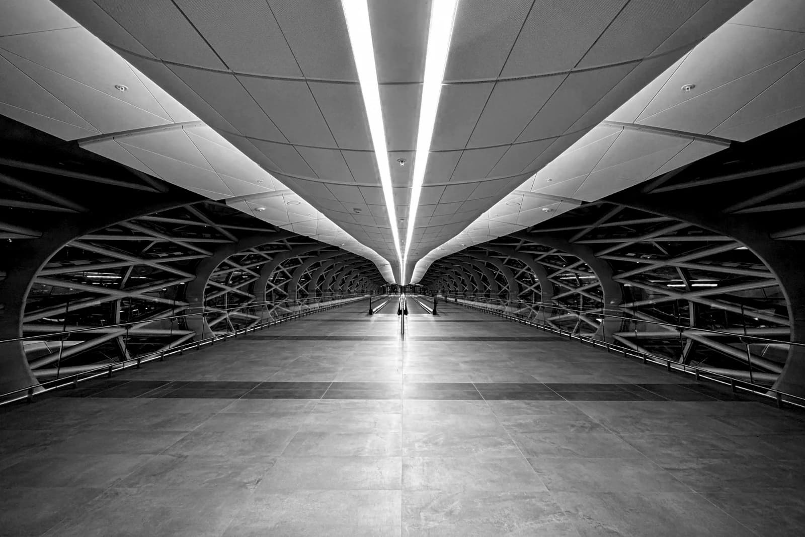 An empty, futuristic-looking walkway with bright lights in Abu Dhabi Terminal A.