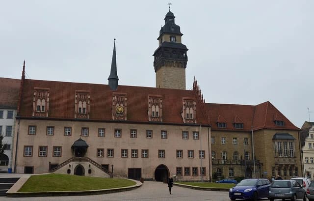 Rathaus Zeitz, a large building with a prominent tower and multiple spires, on an overcast day.