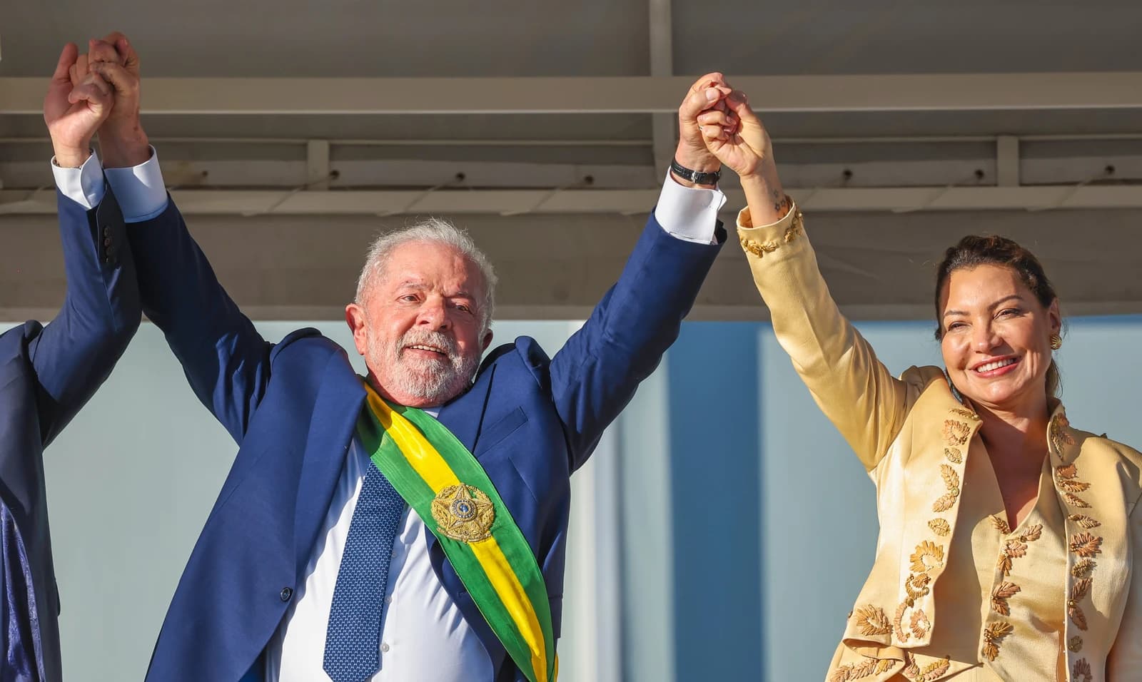 Luiz Inácio Lula da Silva, President of Brazil, raises clasped hands with his wife.