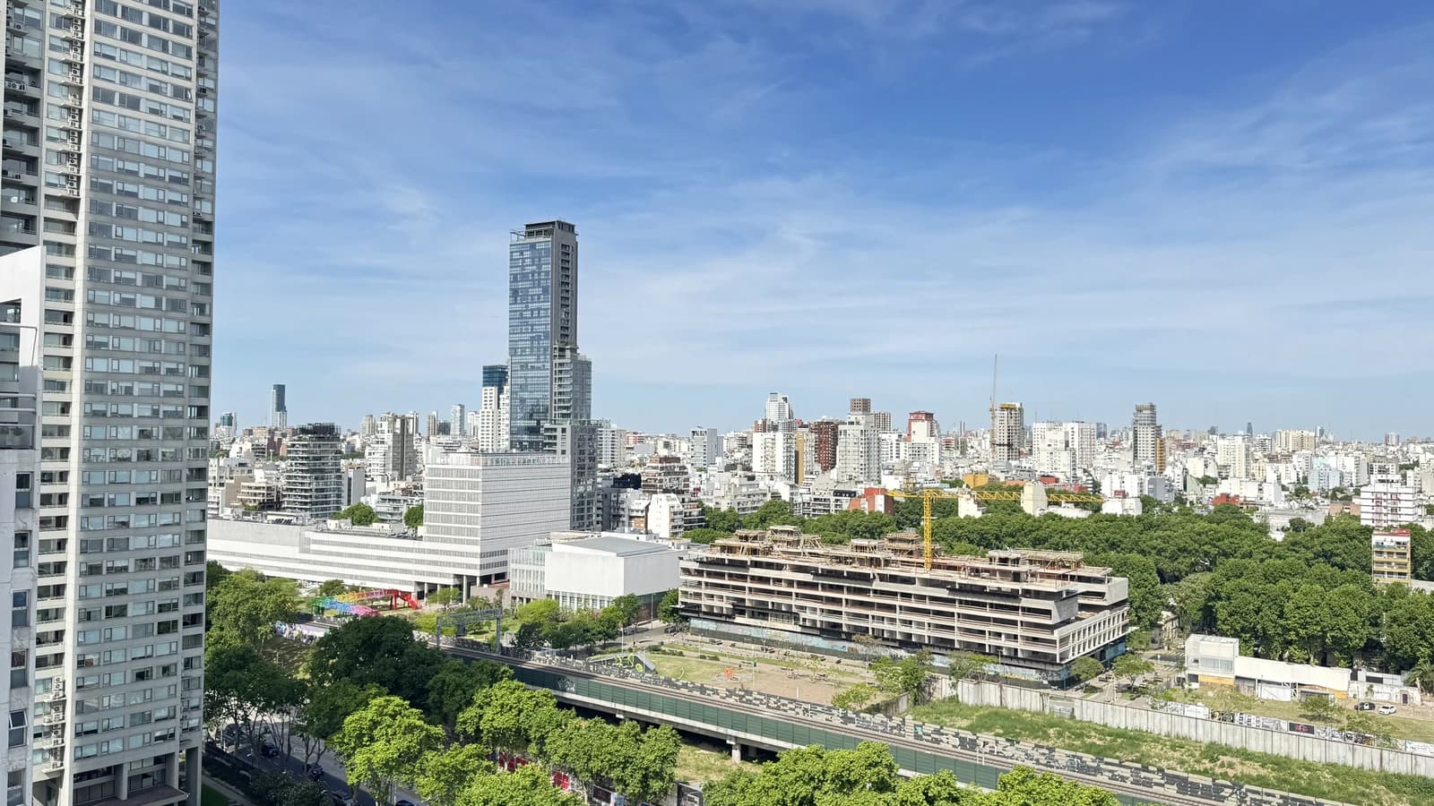An urban landscape view of Palermo, Argentina, with high-rise buildings and green spaces.