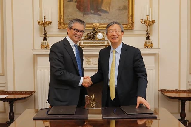Central Bank of Chile and People's Bank of China officials shaking hands in an ornate room.