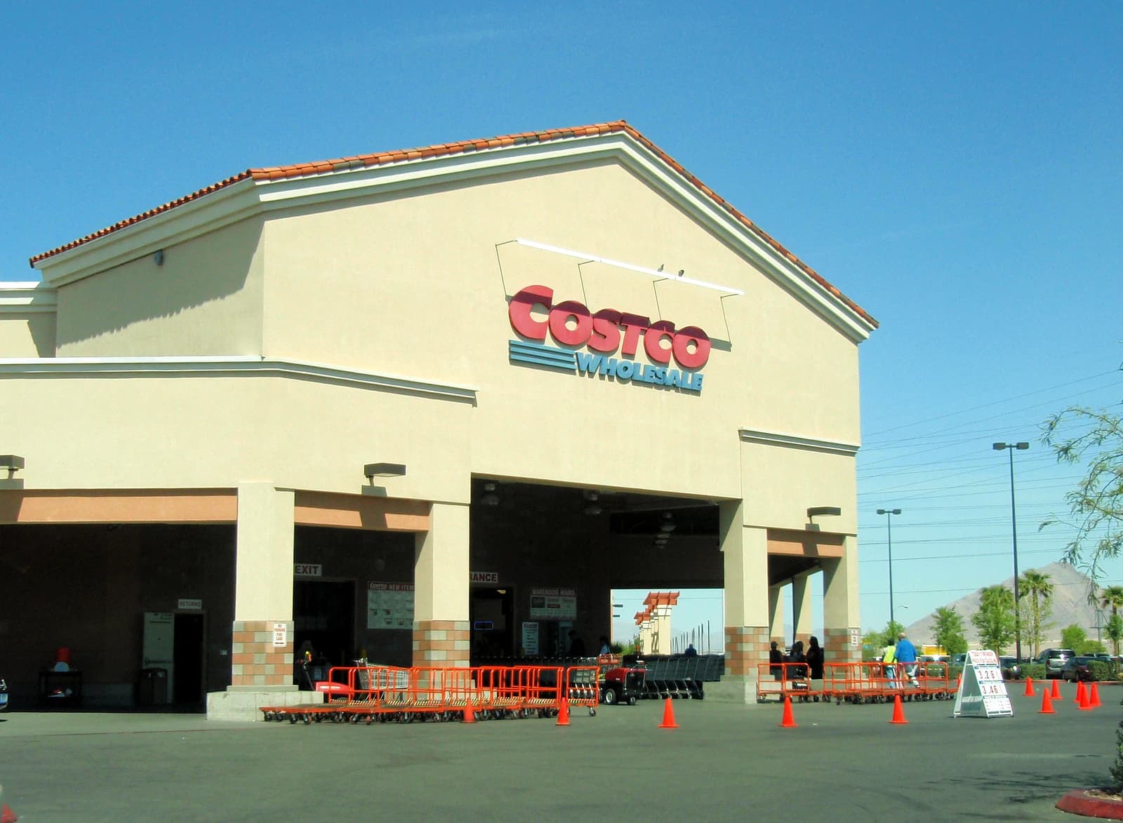 Exterior view of a Costco Wholesale store entrance on a sunny day.