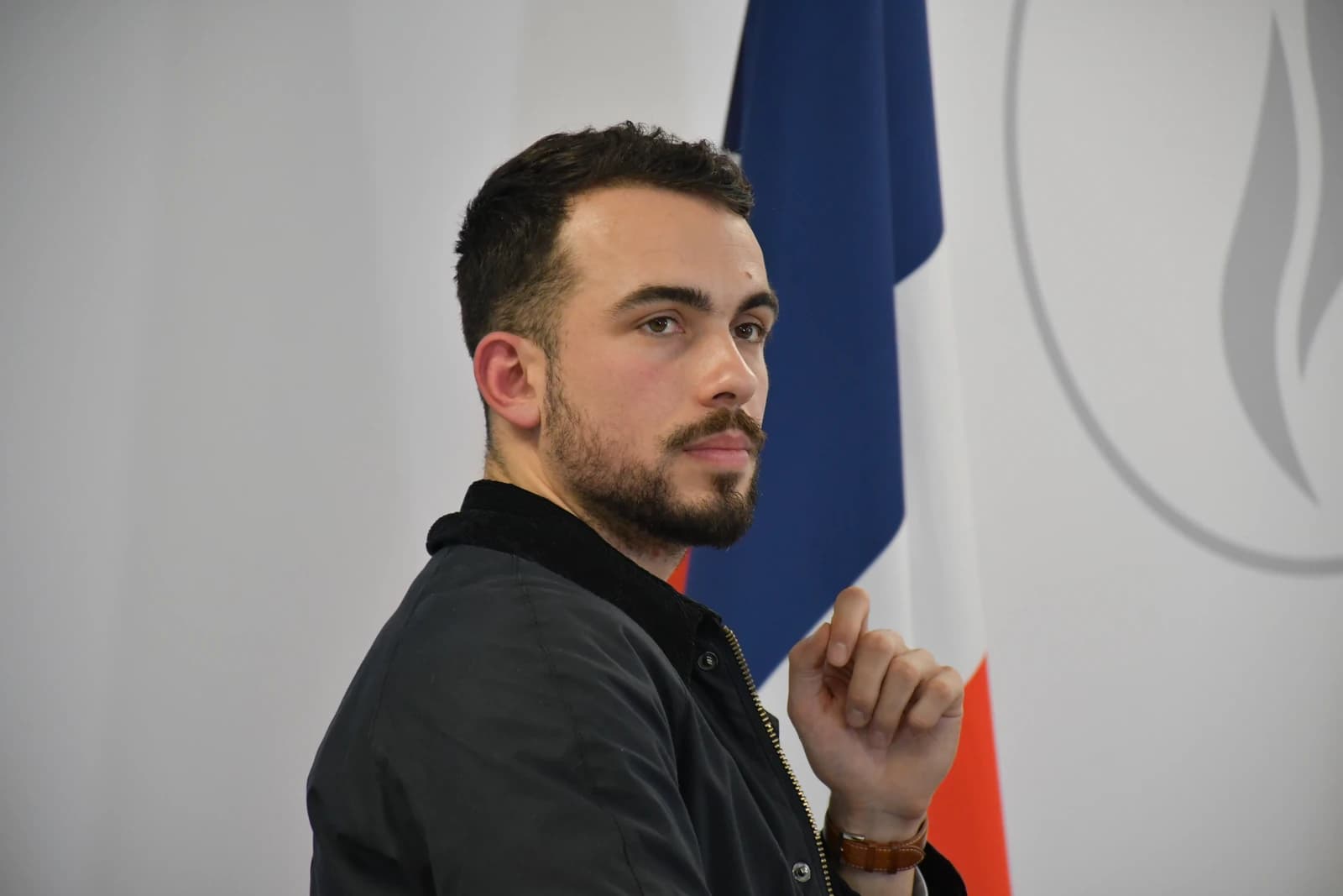 Pierre-Romain Thionnet, National Director of the RN Youth, sitting at an event.