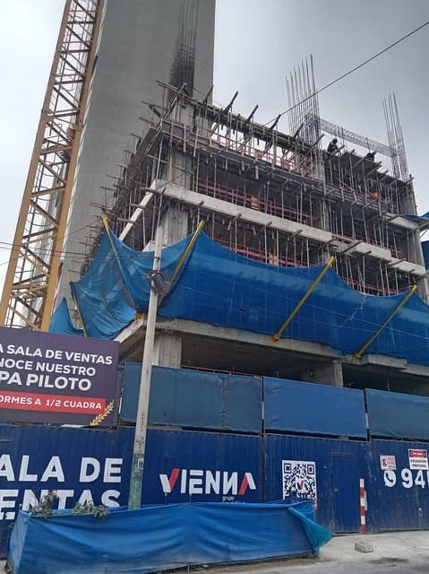 Edificio Sukha building under construction with a large crane next to it.