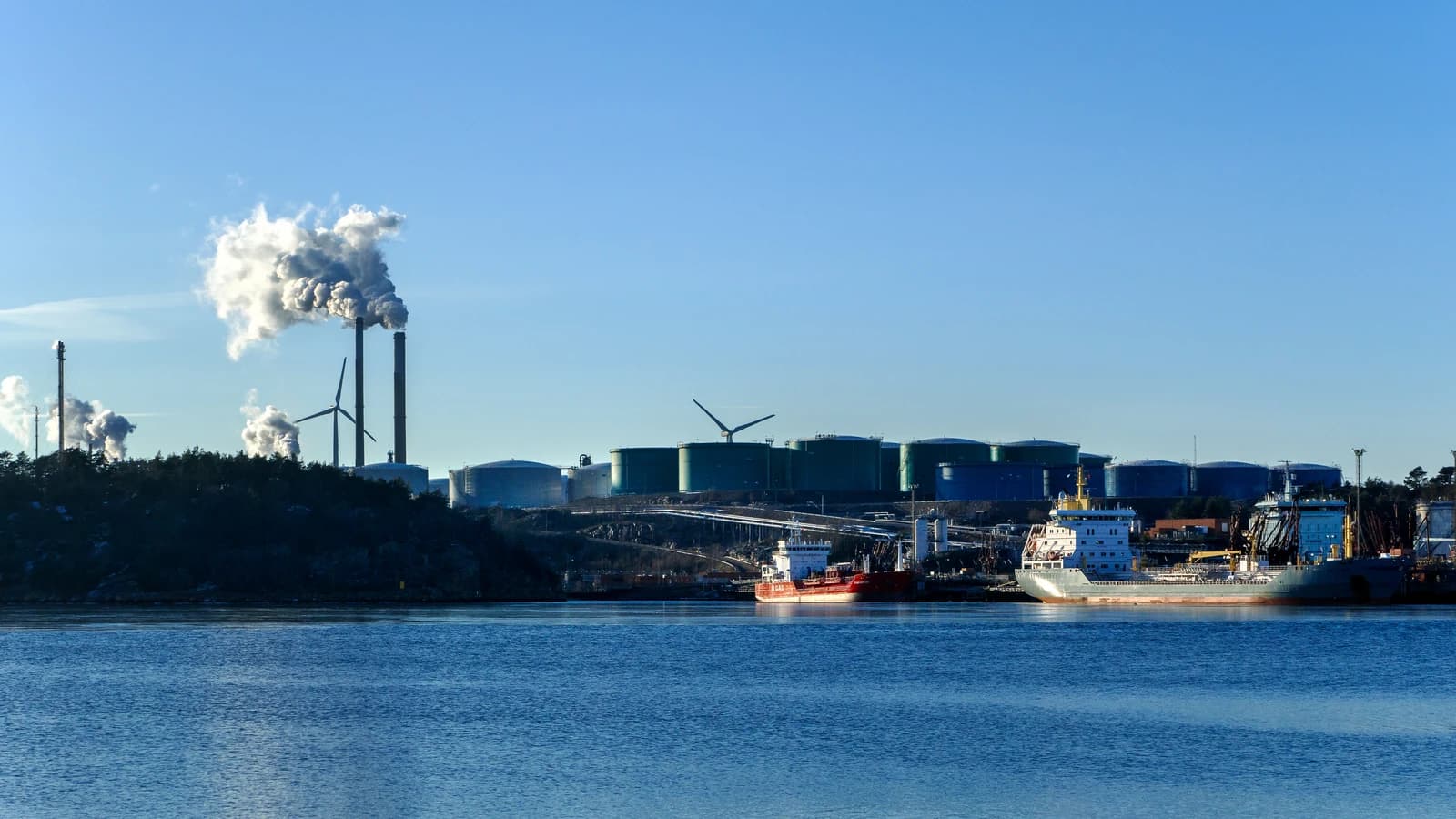 Preemraff oil refinery with industrial towers emitting smoke, located by Brofjorden.