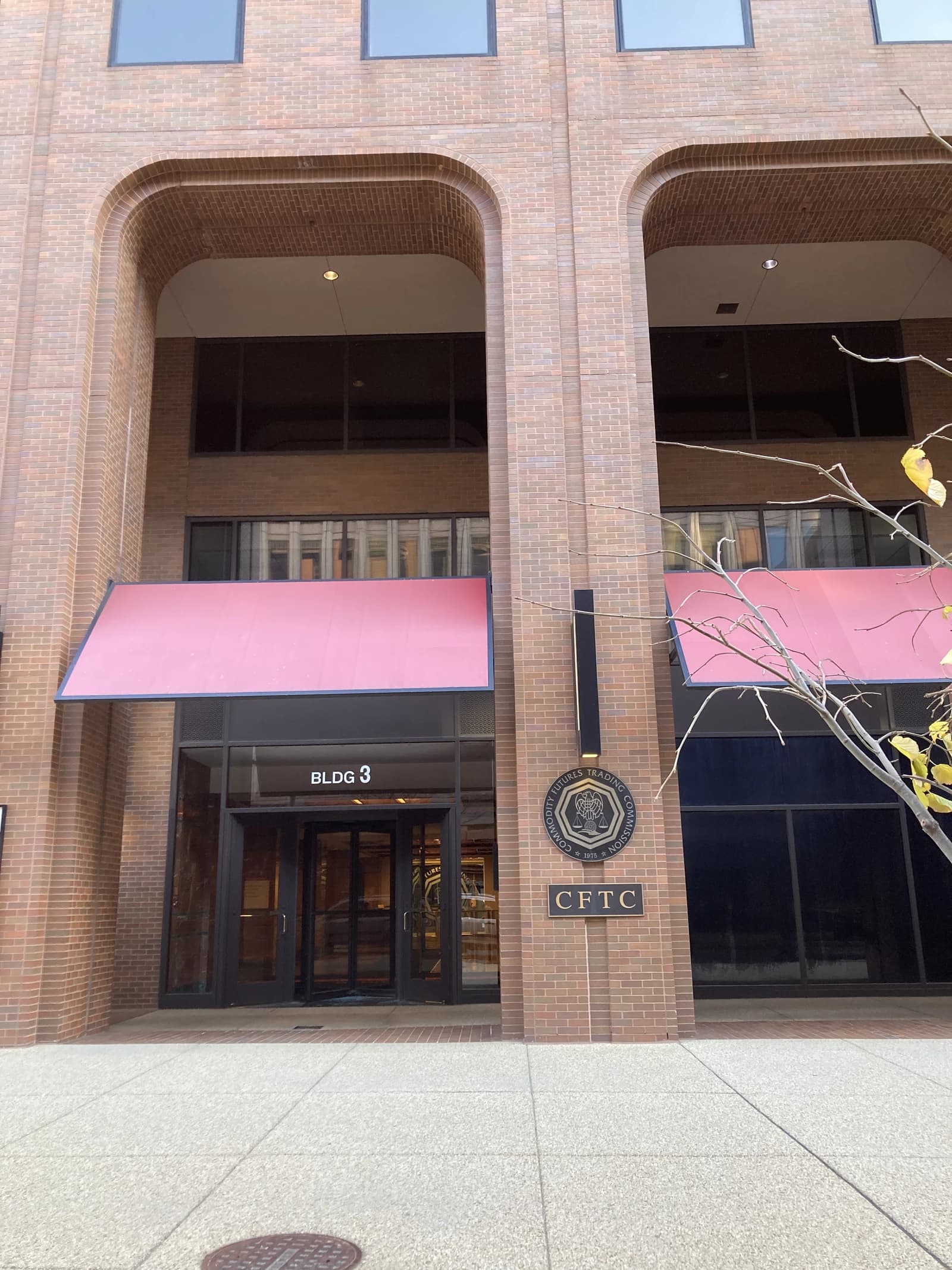Exterior of the Commodity Futures Trading Commission headquarters building with a sign.