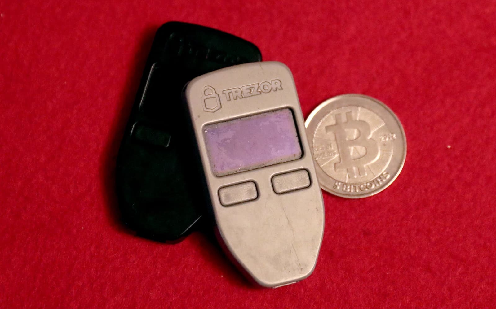 Two Trezor One hardware wallets and a physical Casascius Bitcoin coin.