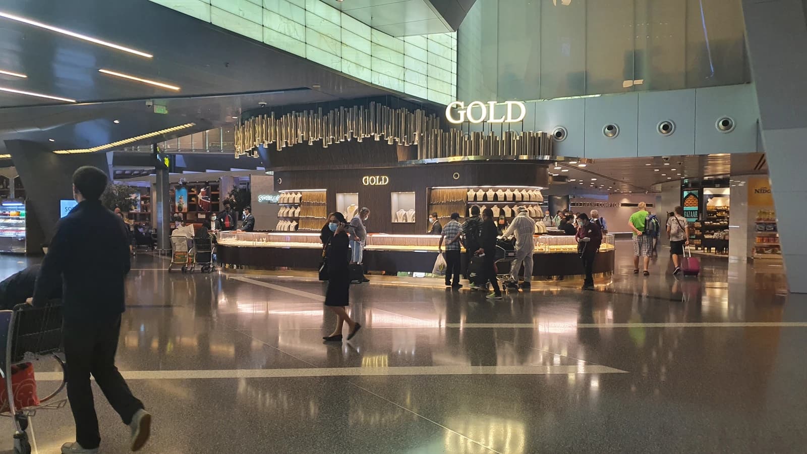 People browse gold jewelry on display at a shop inside Hamad International Airport.
