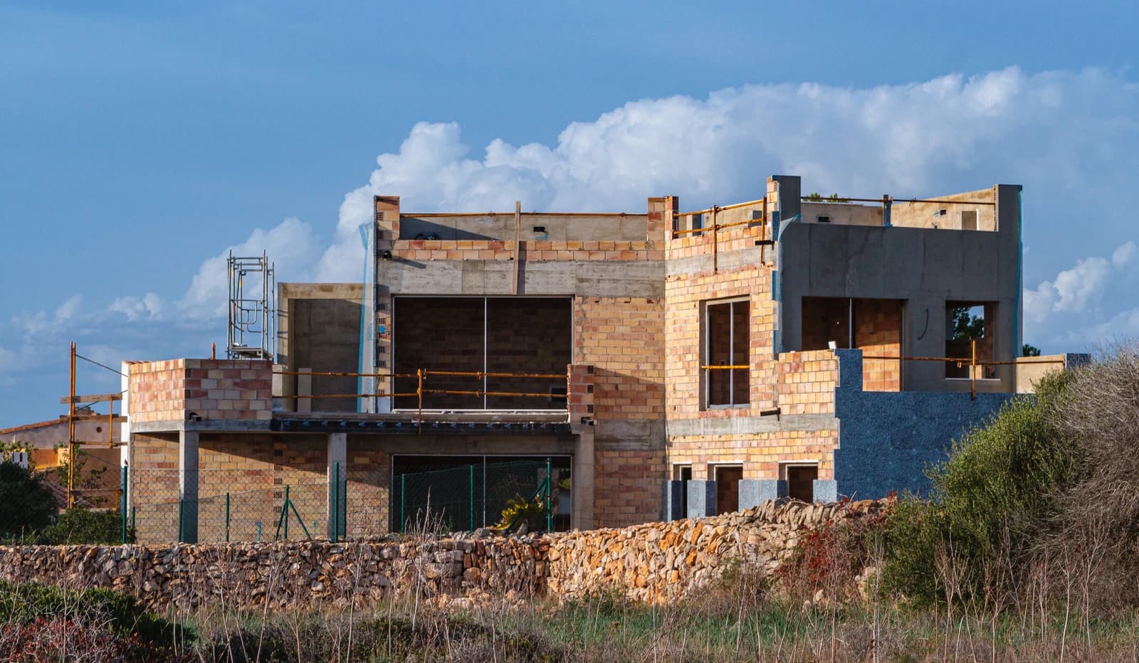 A modern building under construction with exposed brick and concrete elements.