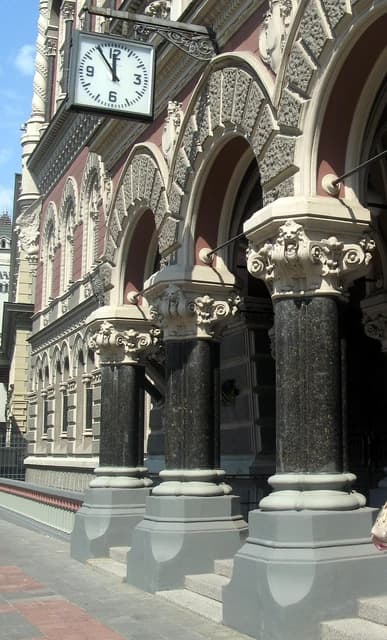 National Bank of Ukraine building facade with ornate columns and a street clock.