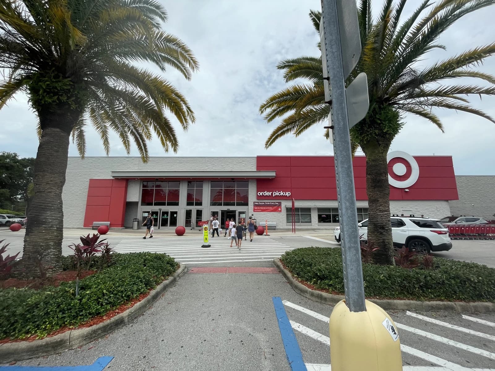 People walk on a crosswalk towards the entrance of a Target store.