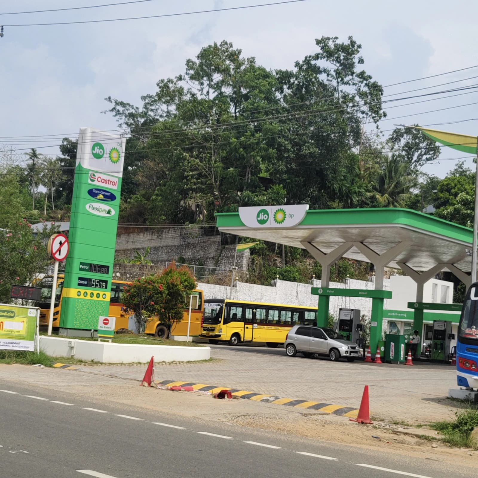 Reliance Petroleum fuel station in Kottarakara, India, with vehicles parked nearby.