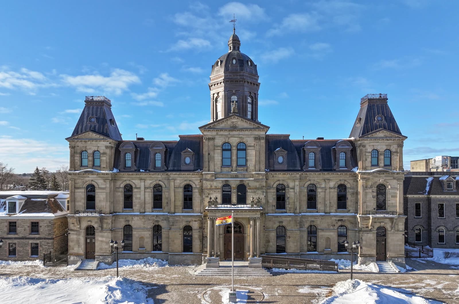 Legislative Assembly of New Brunswick building in Fredericton, Canada, with a flag flying.