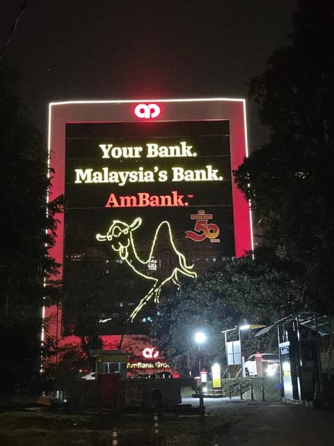 Exterior view of Menara AmBank building at night, showing illuminated signage.