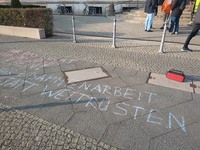 Chalked slogans on pavement during an anti-Artificial Intelligence protest.