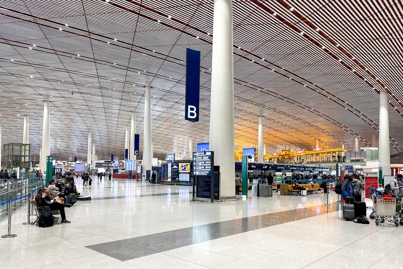 Departure Hall at Beijing Capital International Airport, Terminal 3, with travelers and luggage.