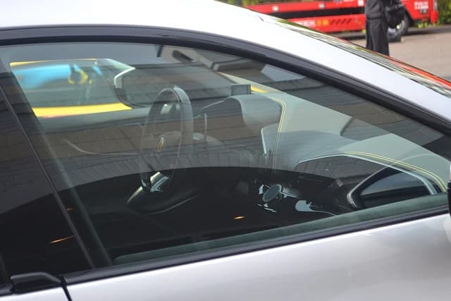 Interior of a silver Ferrari Purosangue supercar, including steering wheel and dashboard.